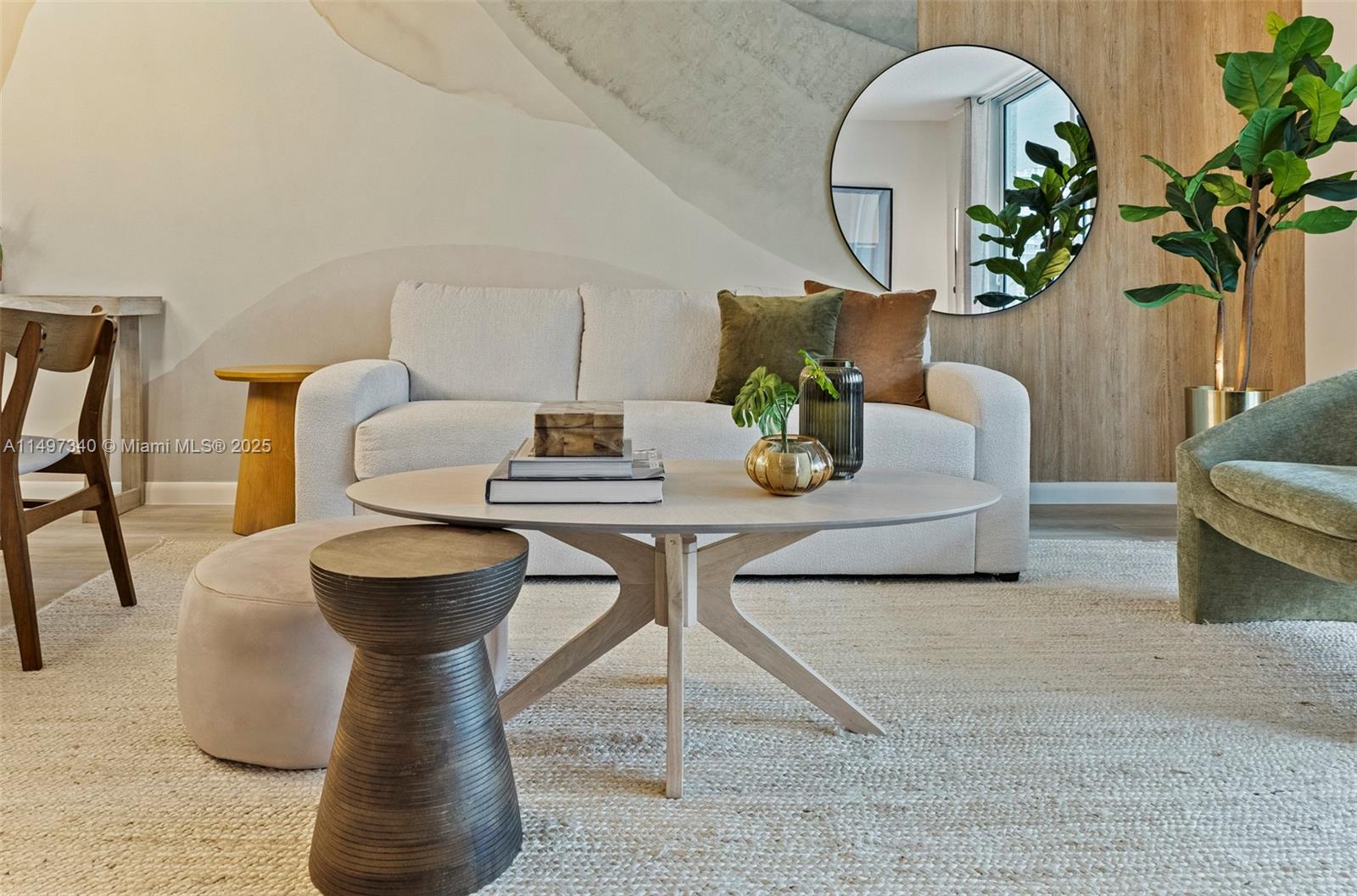 A living room features a white sofa, a round coffee table, and a circular wall mirror — 1200 Brickell Bay Dr # 3619, Miami FL 33131, MIAMI, FL