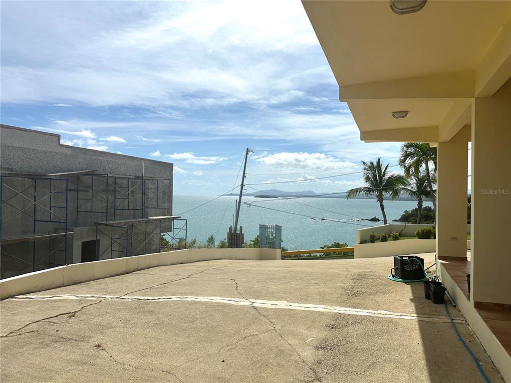 A concrete driveway overlooks the ocean from a covered patio area next to a building — 38 FLOR MARINA MAR CARIBE, NAGUABO, PR