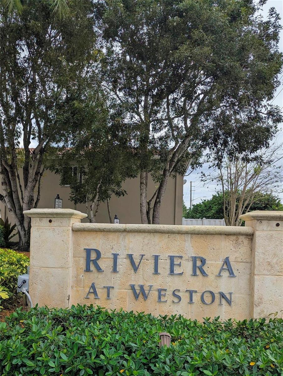 A stone monument sign reads Riviera at Weston in front of trees and a building — 158 Riviera Circle # 3, Weston FL 33326, WESTON, FL