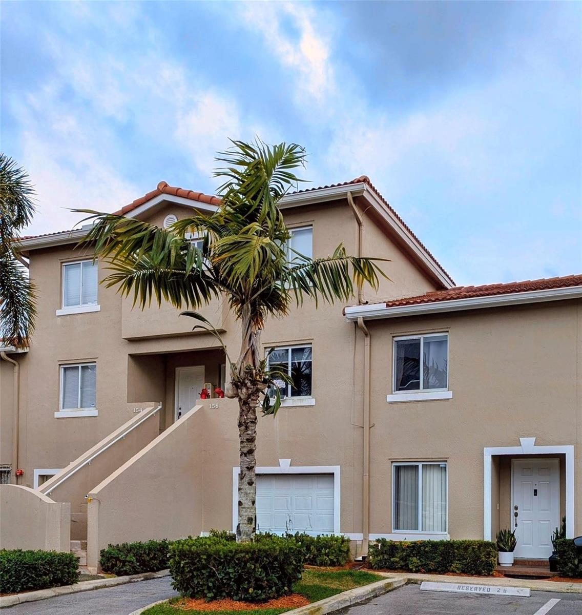 A two-story tan stucco townhouse with a palm tree in the front yard — 158 Riviera Circle # 3, Weston FL 33326, WESTON, FL
