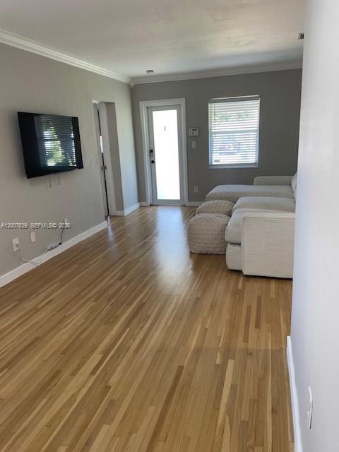 A living room with light wood floors, a wall-mounted television, and a white sectional sofa — 5886 SW 42 St, Miami FL 33155, MIAMI, FL