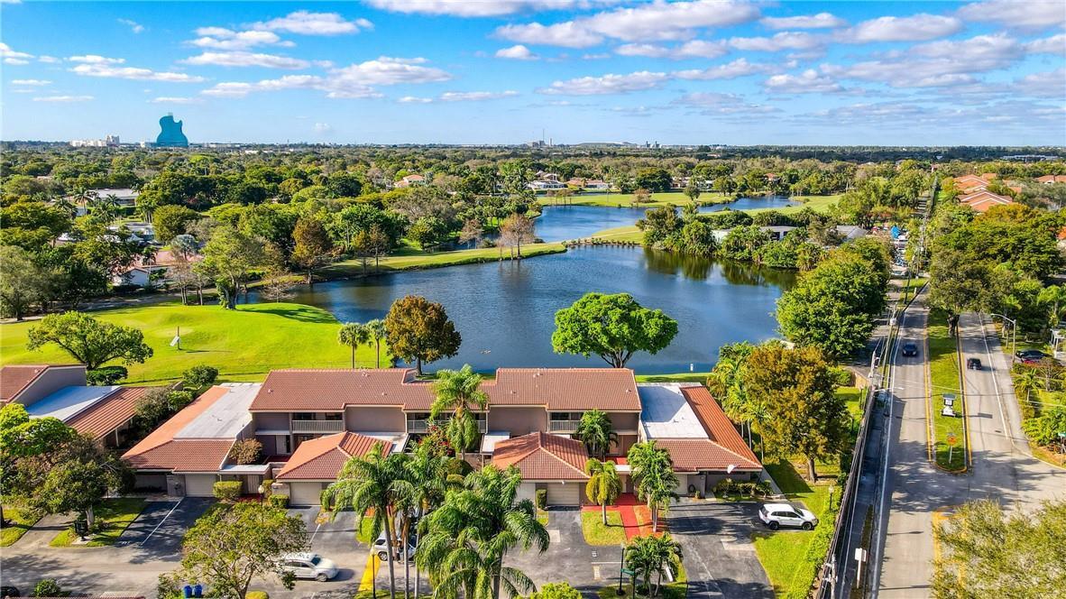 An aerial view shows a multi-unit townhouse complex situated next to a lake and golf course — 103 St Andrews Road, Hollywood FL 33021, HOLLYWOOD, FL
