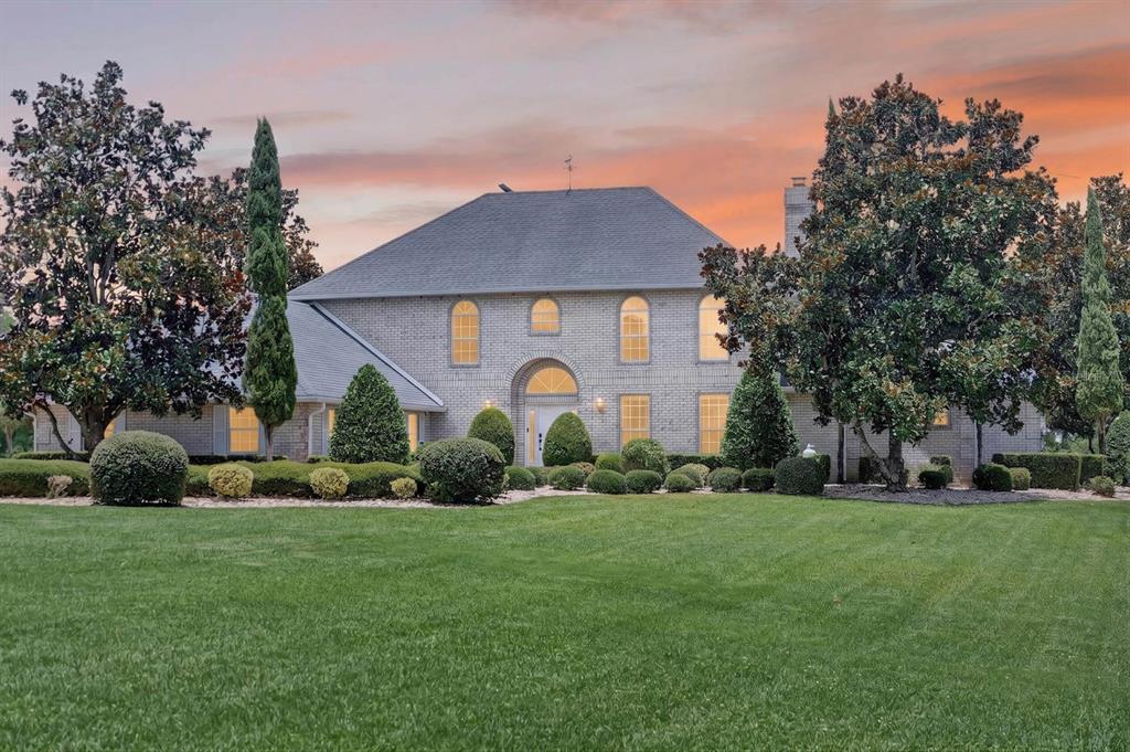 A two-story brick house with a large lawn and mature trees at sunset — 350 FOX HOLLOW FARMS ROAD, PIERSON, FL