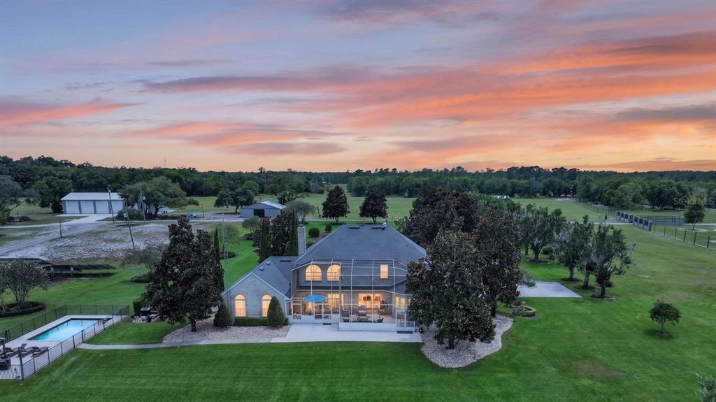 An aerial view of a house with a screened-in patio, pool, and large grassy yard — 350 FOX HOLLOW FARMS ROAD, PIERSON, FL