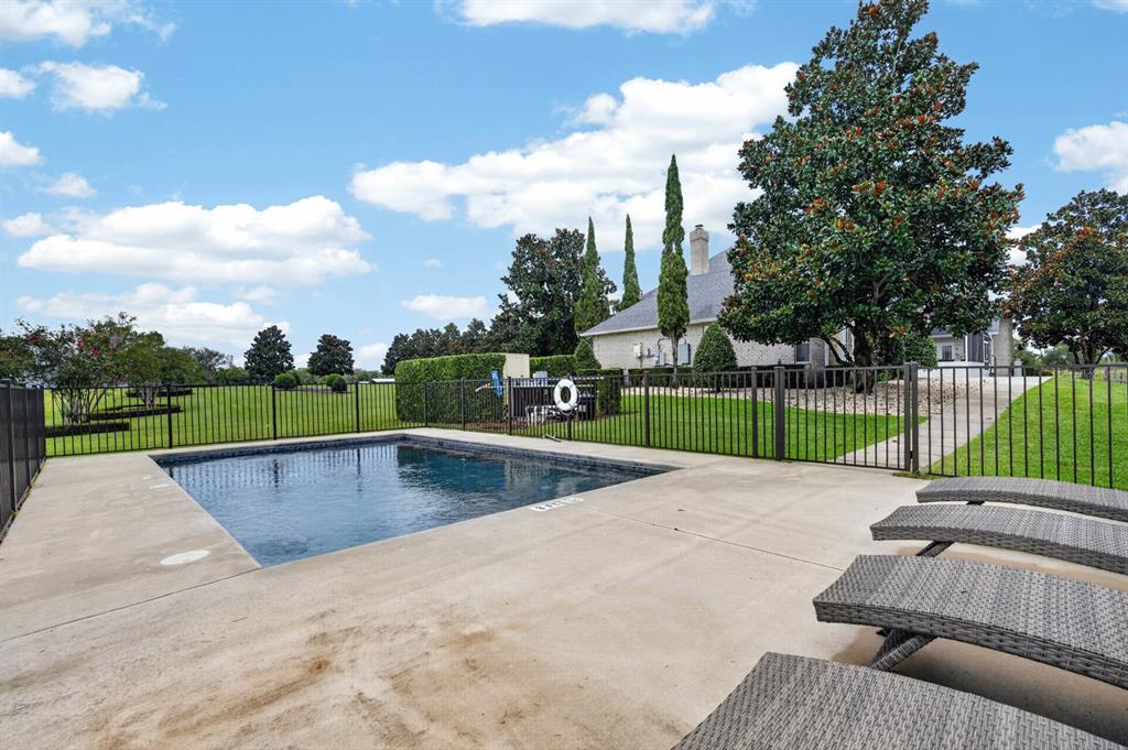 A fenced swimming pool with lounge chairs on a concrete deck near a house — 350 FOX HOLLOW FARMS ROAD, PIERSON, FL