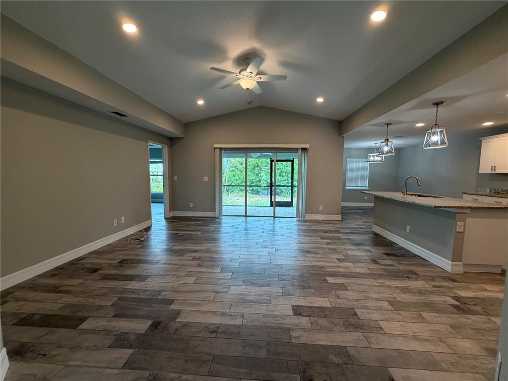 An empty bedroom features light gray walls, wood-look tile flooring, a ceiling fan, and a window — 315 SWEETWATER DRIVE, ROTONDA WEST, FL