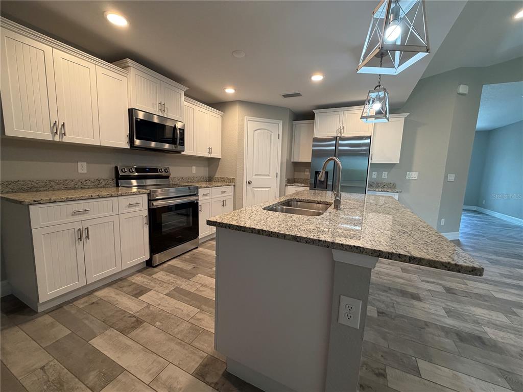 An empty bedroom features light gray walls, wood-look tile flooring, a ceiling fan, and closet doors — 315 SWEETWATER DRIVE, ROTONDA WEST, FL