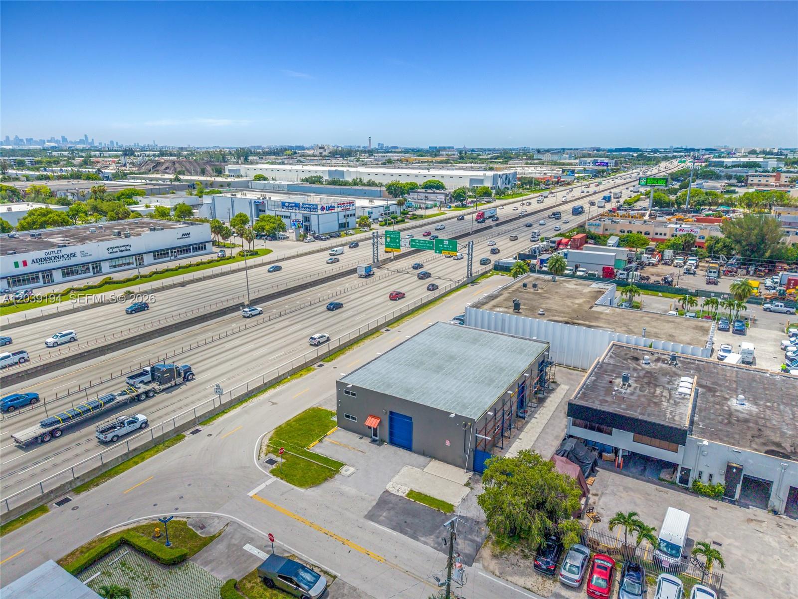 An aerial view shows a commercial building situated next to a multi-lane highway — 5280 NW 77th Ct, Doral FL 33166, DORAL, FL