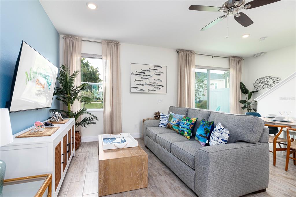 A living room features a gray sofa, a wooden coffee table, and a television — 2960 ON THE ROCKS POINT, KISSIMMEE, FL