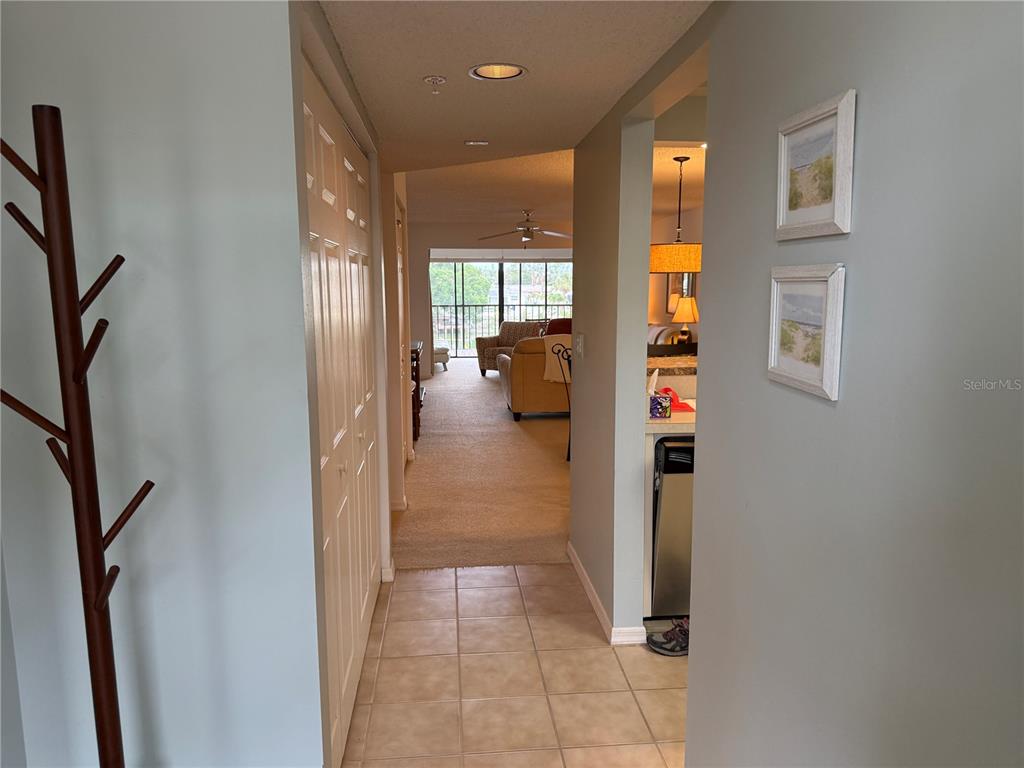 A tiled entryway leads into a carpeted living area with a view of a balcony — 5555 ASHTON LAKE DRIVE UNIT 5555, SARASOTA, FL