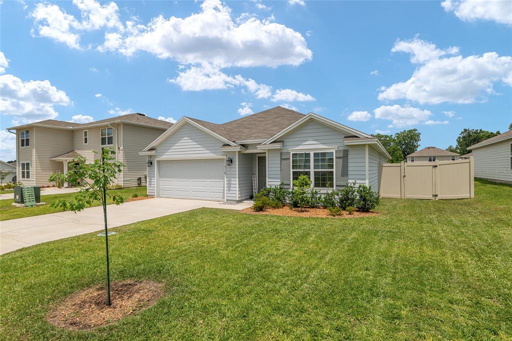 A light blue single-story house with a two-car garage and a front lawn — 17478 NW 172ND AVENUE, ALACHUA, FL