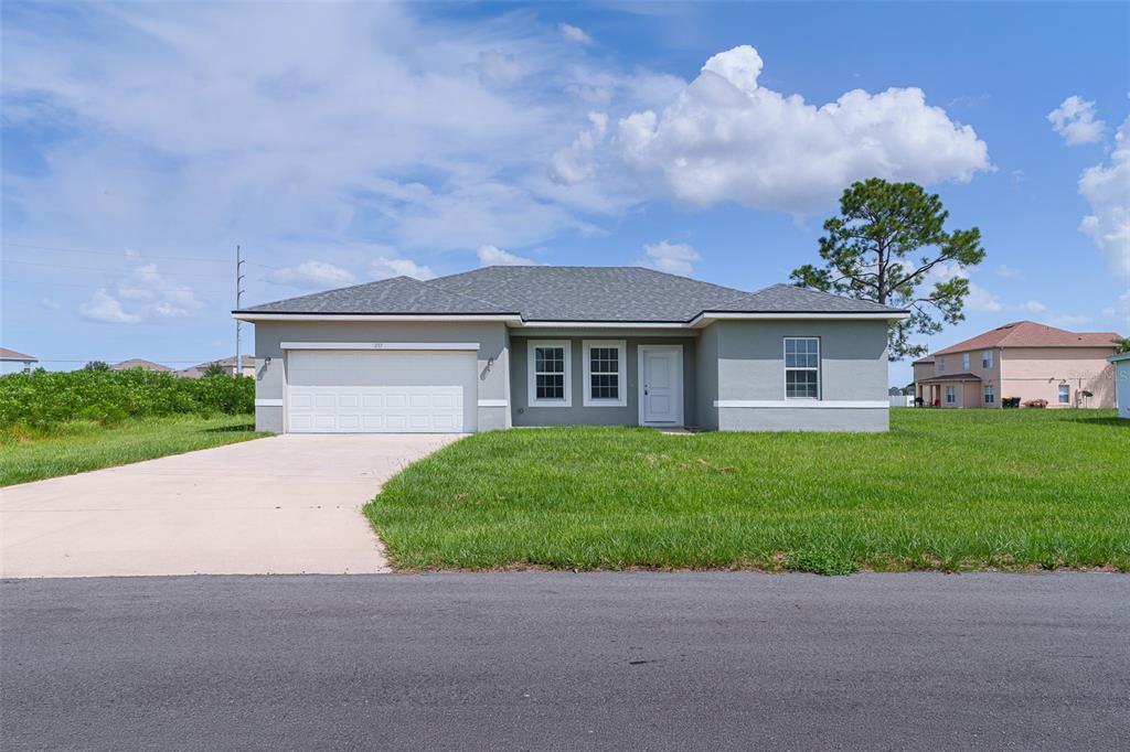 A single-story gray house with a two-car garage and a concrete driveway — 237 CIMARRON DRIVE, POINCIANA, FL