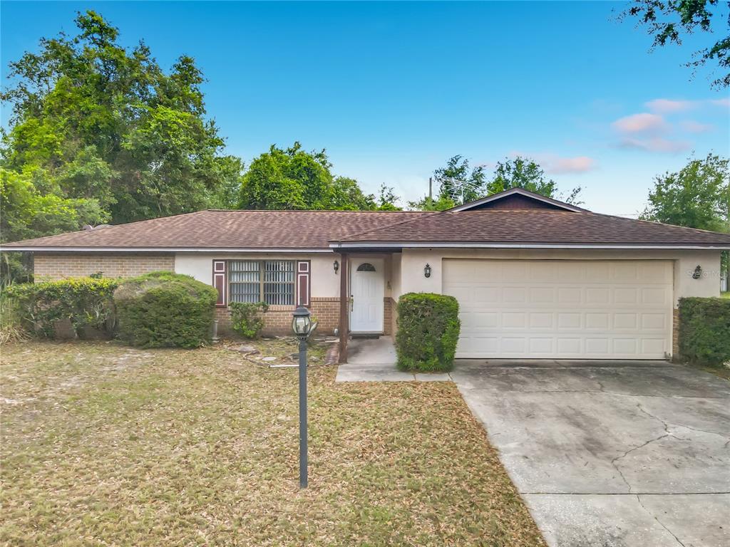 A single-story house with a brick facade, a two-car garage, and a front lawn — 625 BRUNSWICK TERRACE, DELTONA, FL