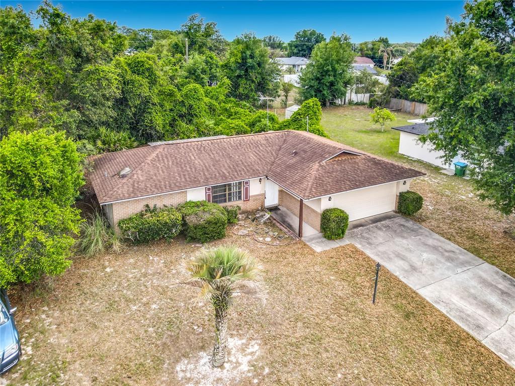 An aerial view of a single-story brick house with a brown roof and attached garage — 625 BRUNSWICK TERRACE, DELTONA, FL