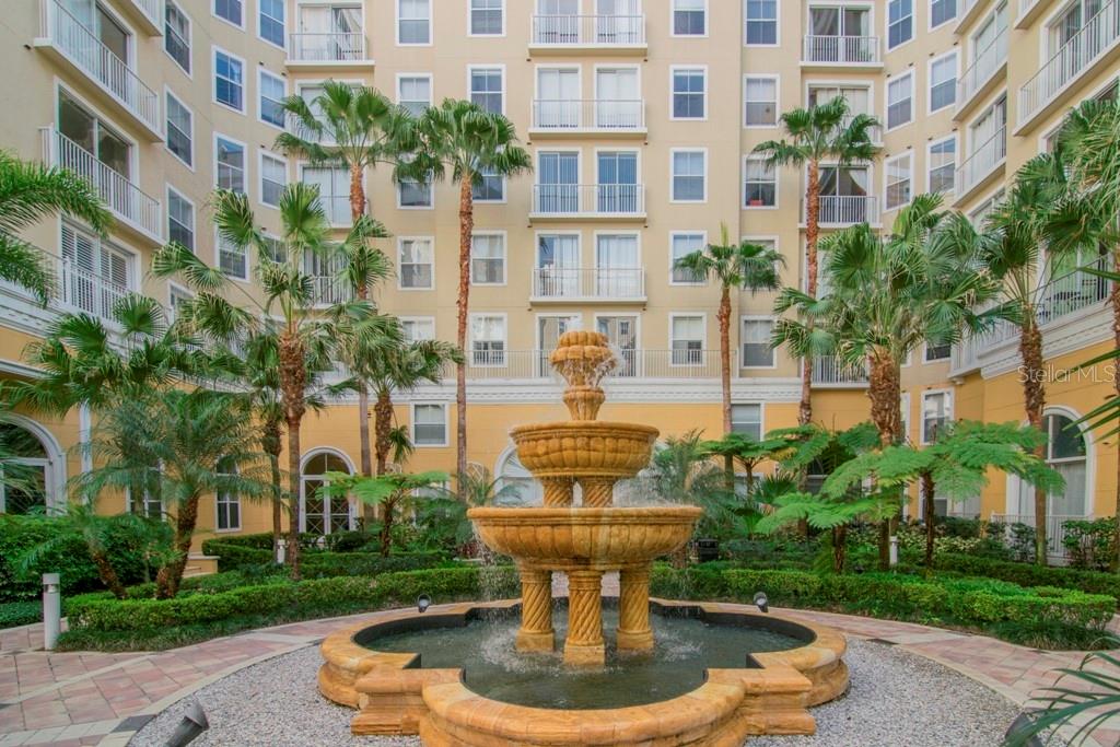 A tiered stone fountain sits in a courtyard surrounded by palm trees and a large building — 700 S HARBOUR ISLAND BOULEVARD UNIT 535, TAMPA, FL