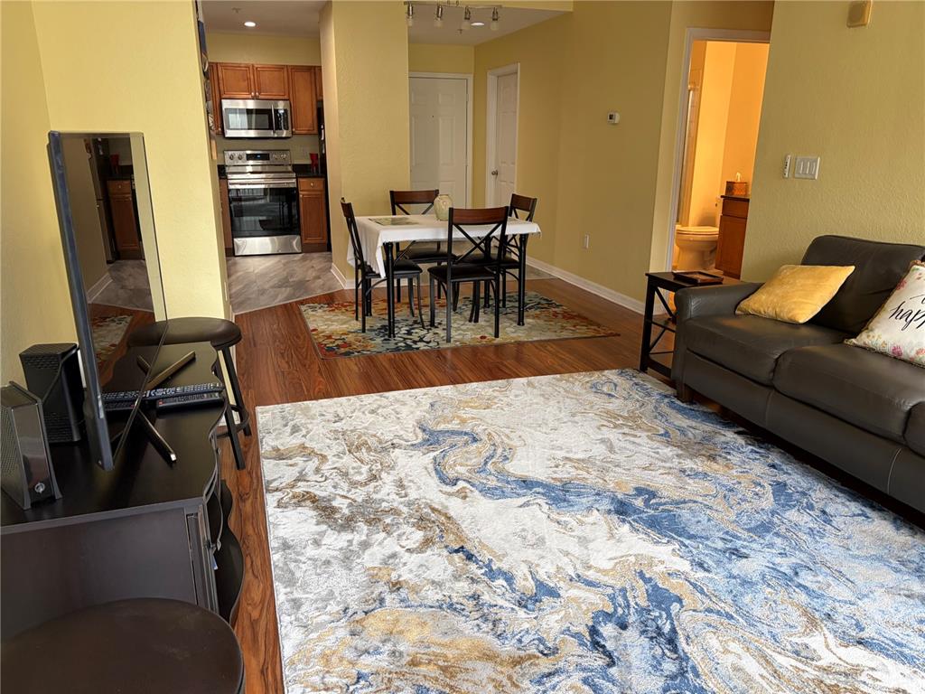 An open-concept living and dining area features wood-look flooring, a dark sofa, and a kitchen — 700 S HARBOUR ISLAND BOULEVARD UNIT 535, TAMPA, FL