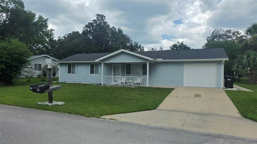A light blue, single-story house with a white garage door and a front porch — 8041 SW 109TH PLACE ROAD, OCALA, FL