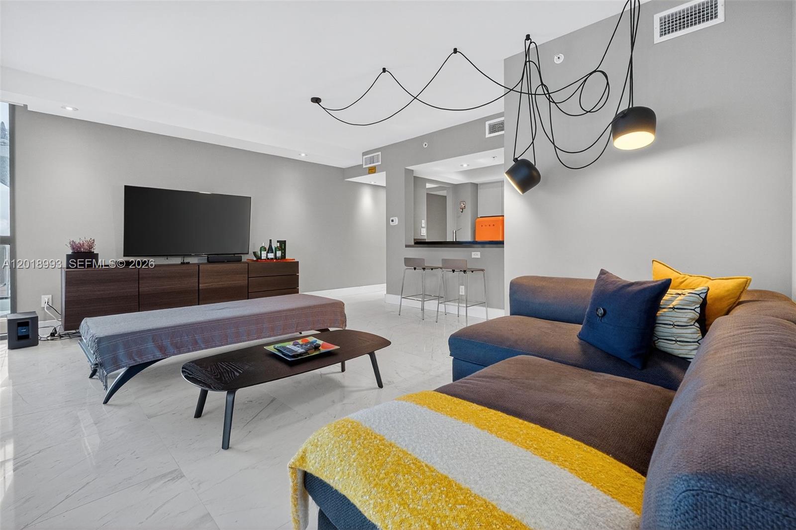 A modern living room features a gray sectional sofa, a coffee table, and pendant lighting — 1500 Ocean Dr # 507, Miami Beach FL 33139, MIAMI BEACH, FL