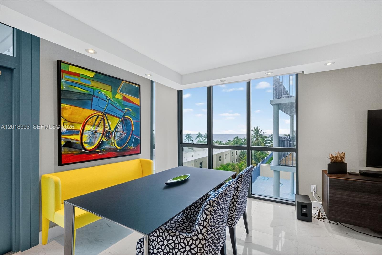 A dining area features a yellow bench, patterned chairs, a black table, and ocean views — 1500 Ocean Dr # 507, Miami Beach FL 33139, MIAMI BEACH, FL