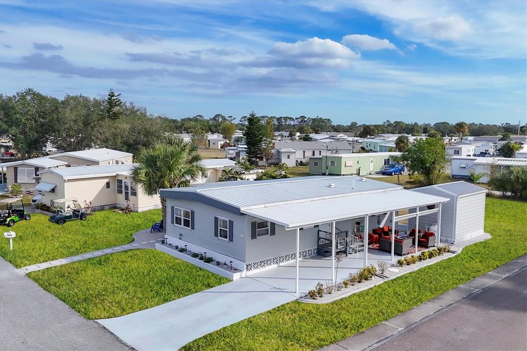 An aerial view of a light gray mobile home with a covered patio and carport — 6401 FLORAL COURT, NORTH PORT, FL
