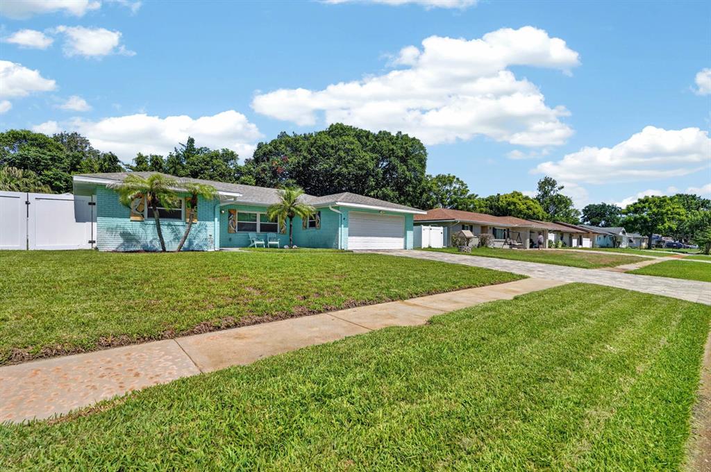 A light blue single-story house with a white garage and a green lawn — 68 RAINTREE DRIVE, PORT ORANGE, FL