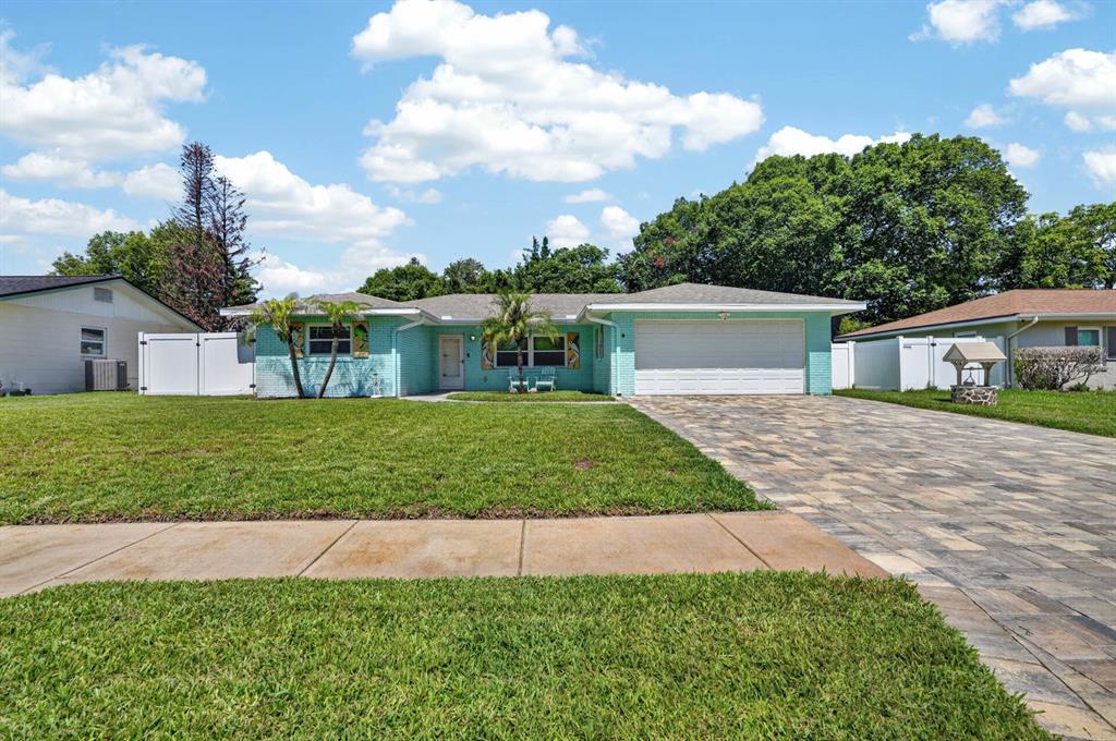 A light blue, single-story house with a paved driveway and a green lawn — 68 RAINTREE DRIVE, PORT ORANGE, FL