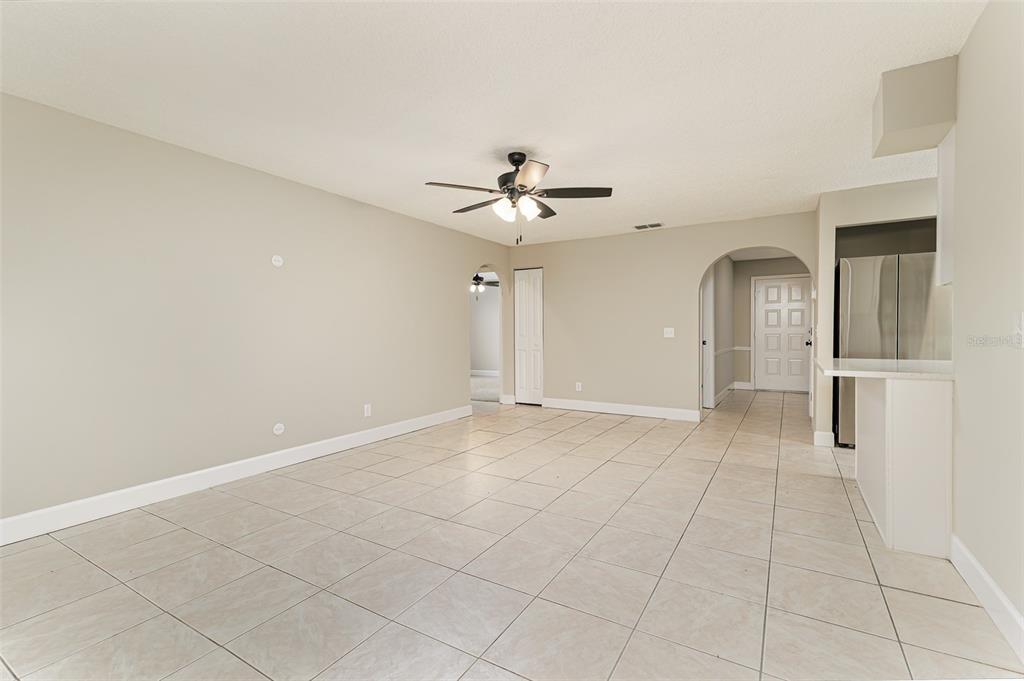 A hallway with tiled floors leads to a carpeted living room and a tiled dining area — 4052 LEHMAN COURT, LAKELAND, FL