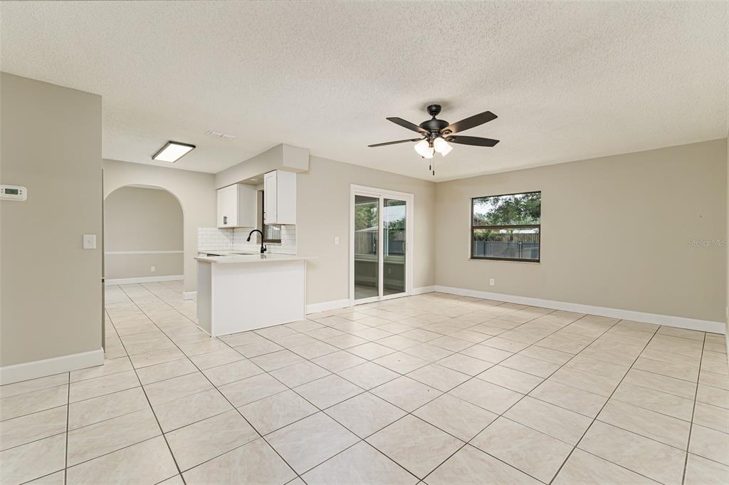 A living room features gray carpet, a white sofa, two armchairs, and a dark cabinet — 4052 LEHMAN COURT, LAKELAND, FL
