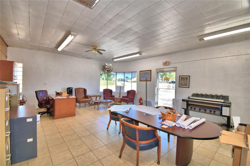An office space features tiled floors, a drop ceiling, a conference table, and desks — 105 S SCENIC HIGHWAY, FROSTPROOF, FL