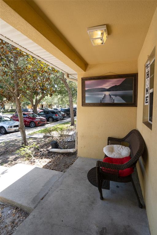 A covered front porch features a wicker bench, a wall-mounted landscape print, and exterior lighting — 10928 KEYS GATE DR, RIVERVIEW, FL