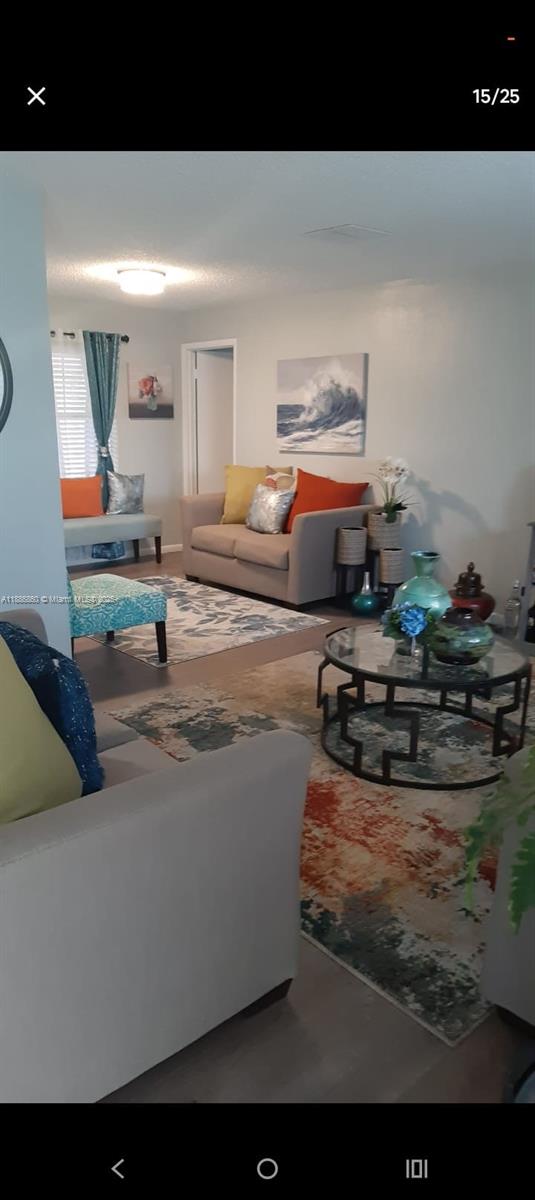 A living room features beige sofas, a glass-topped coffee table, and a colorful area rug — 3809 palazzo, Sebring FL 33872, SEBRING, FL