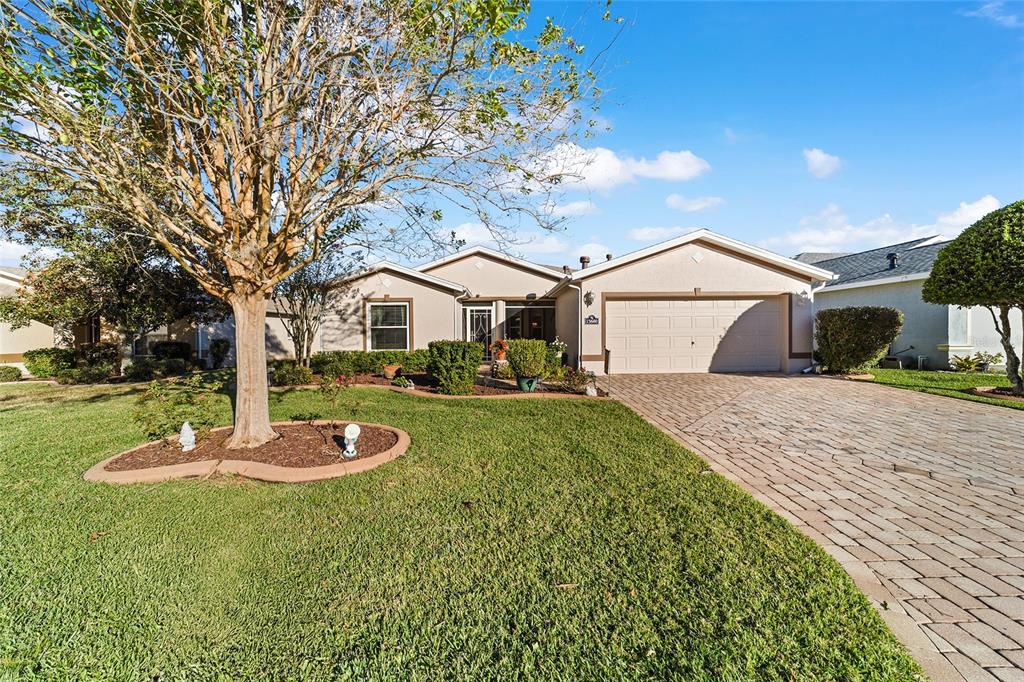 A single-story house with a beige exterior, a paved driveway, and a large front tree — 15680 SW 13TH CIRCLE, OCALA, FL