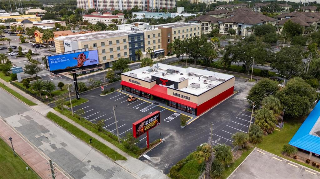 An aerial view shows a restaurant building with a parking lot and a large billboard — 6071 W IRLO BRONSON MEMORIAL HIGHWAY, KISSIMMEE, FL