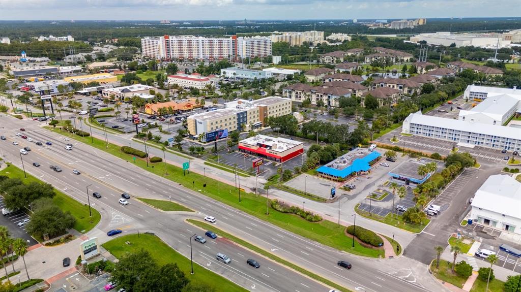 An aerial view shows a multi-lane road, commercial buildings, and apartment complexes — 6071 W IRLO BRONSON MEMORIAL HIGHWAY, KISSIMMEE, FL