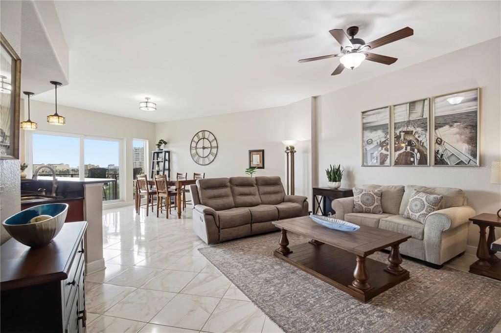 An open-concept living and dining area features tile flooring, neutral walls, and a ceiling fan — 501 HABEN BOULEVARD UNIT 605, PALMETTO, FL