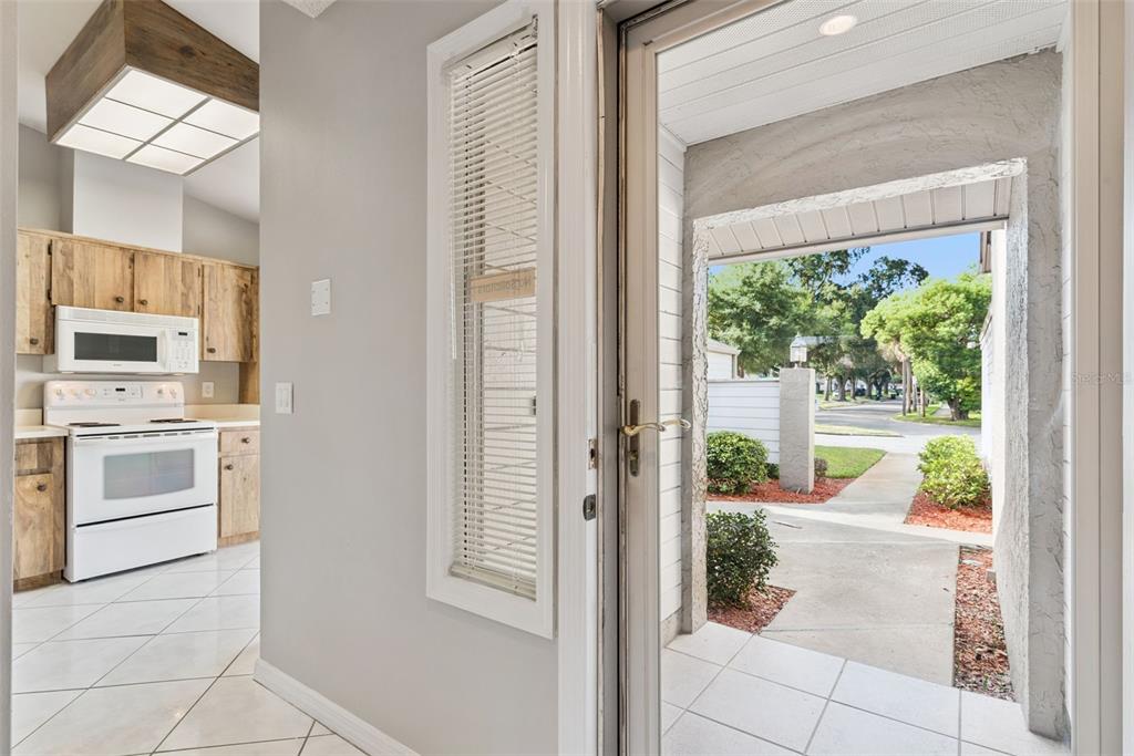 A view from an entryway looking into a kitchen with wood cabinets and white appliances — 419 WARRENTON ROAD UNIT 419, WINTER PARK, FL