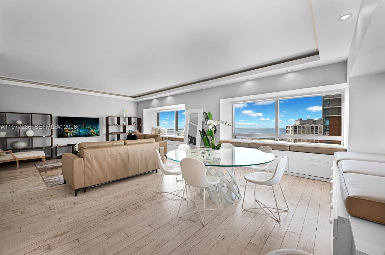A living and dining room features light wood floors, a glass table, and large windows — 1435 Brickell Ave # 3401, Miami FL 33131, MIAMI, FL