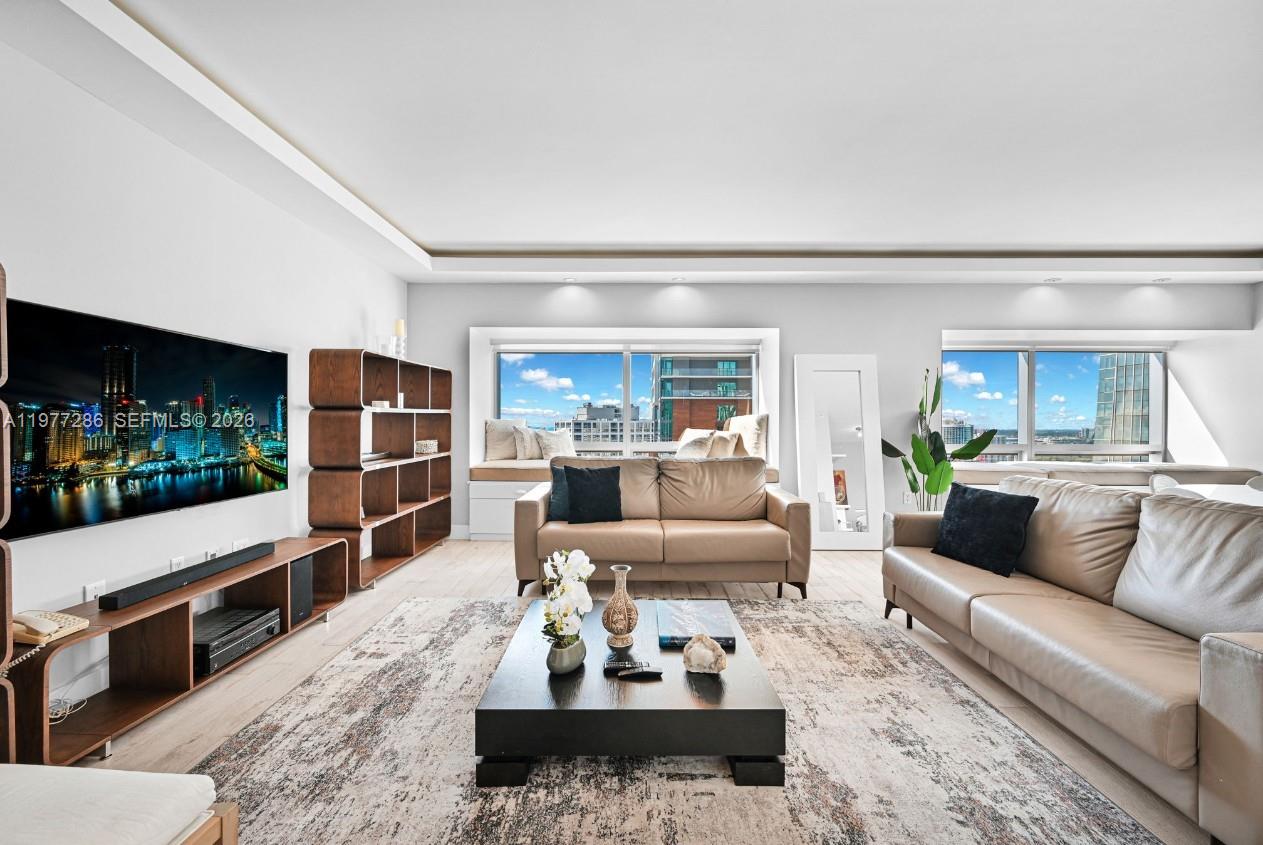 A living room features two leather sofas, a coffee table, and large windows with city views — 1435 Brickell Ave # 3401, Miami FL 33131, MIAMI, FL