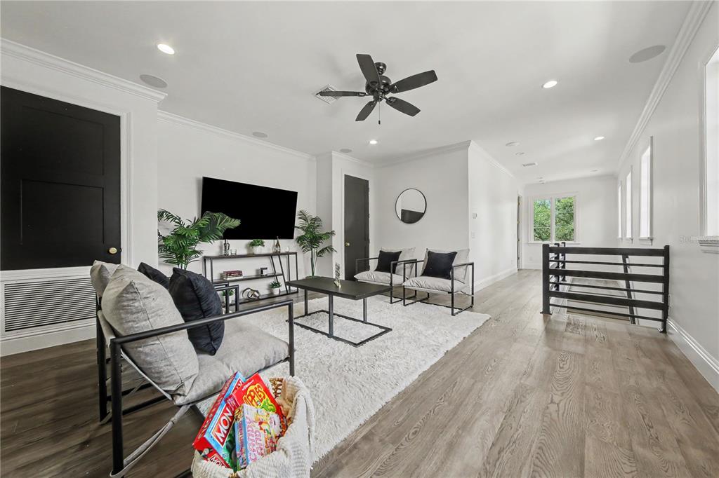 An open-concept living room and kitchen feature light wood floors, white walls, and modern furniture — 1750 WALNUT AVENUE, WINTER PARK, FL