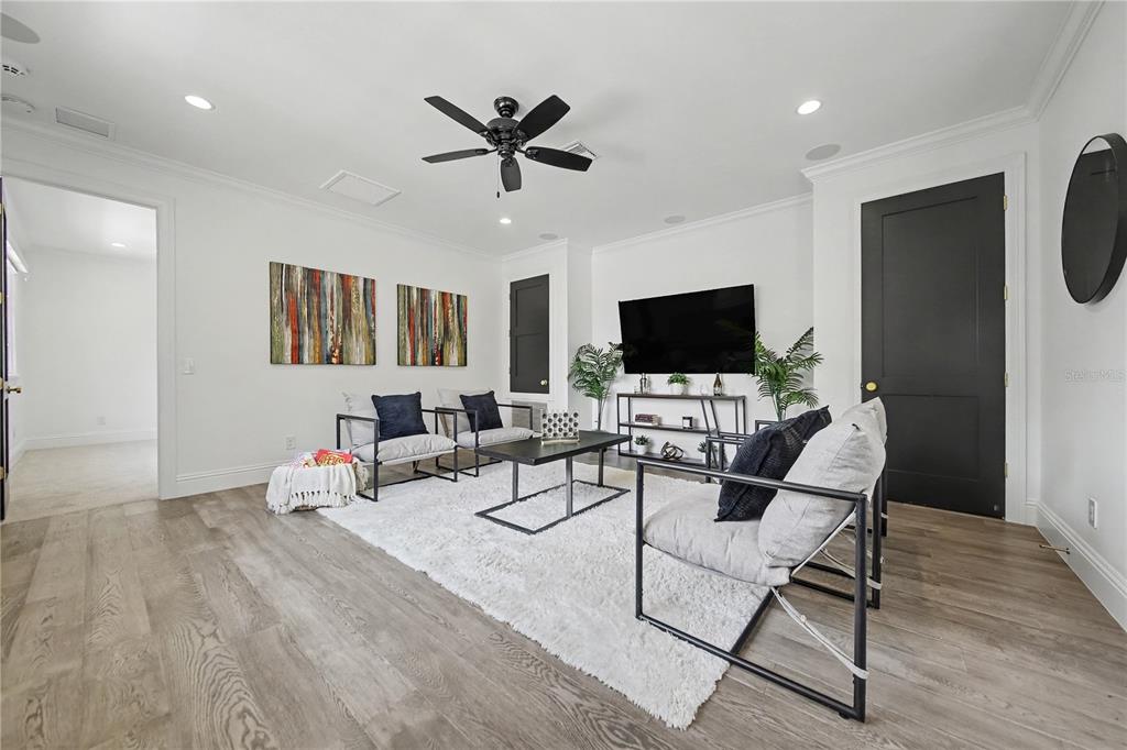 A bright, open-concept living and dining area features wood flooring, a fireplace, and sliding doors — 1750 WALNUT AVENUE, WINTER PARK, FL
