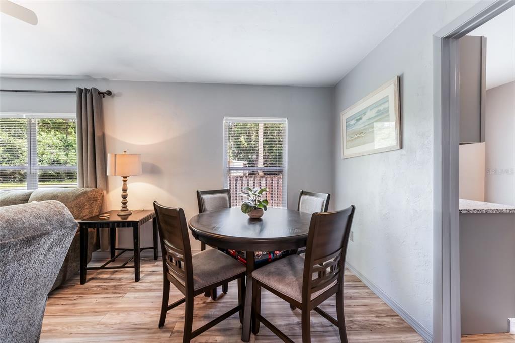 A dining area features a round wooden table with four chairs and light wood flooring — 302 PARK AVENUE, HASTINGS, FL