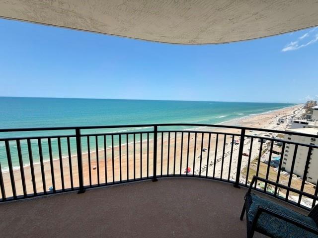 A high-angle view from a balcony overlooking a sandy beach and the ocean — 2555 S ATLANTIC AVENUE UNIT 1704, DAYTONA BEACH SHORES, FL