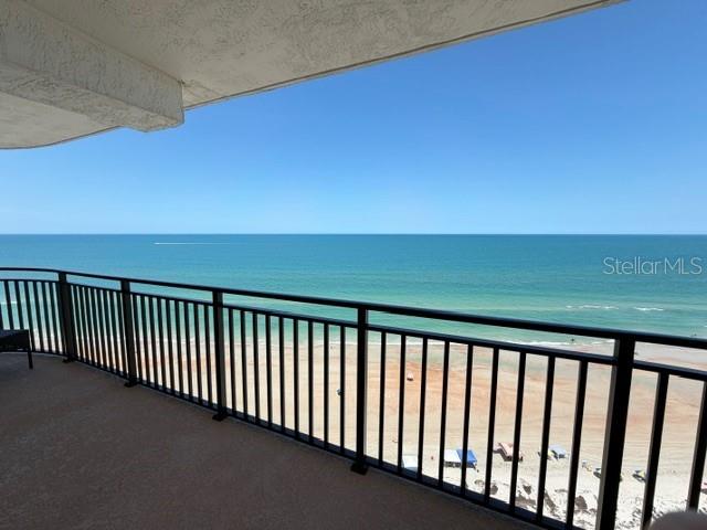 A balcony with a black metal railing overlooks a sandy beach and the ocean — 2555 S ATLANTIC AVENUE UNIT 1704, DAYTONA BEACH SHORES, FL