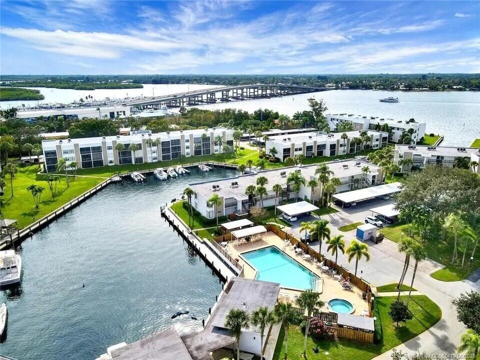 An aerial view of a waterfront apartment complex with a swimming pool and boat slips — 1950 SW Palm City Road # 102, Stuart FL 34994, STUART, FL