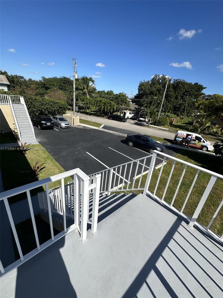 An elevated view of an outdoor staircase leading to a parking lot with several cars — 6101 Garfield St, Hollywood FL 33024, HOLLYWOOD, FL