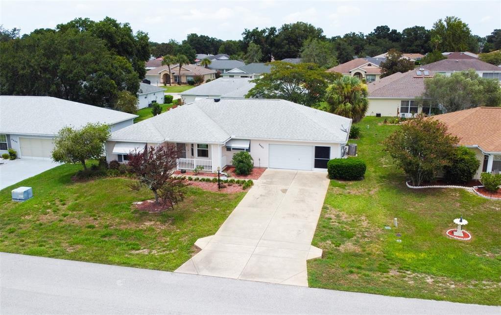 An aerial view of a single-story suburban house with a concrete driveway and lawn — 8480 SW 61ST TERRACE ROAD, OCALA, FL