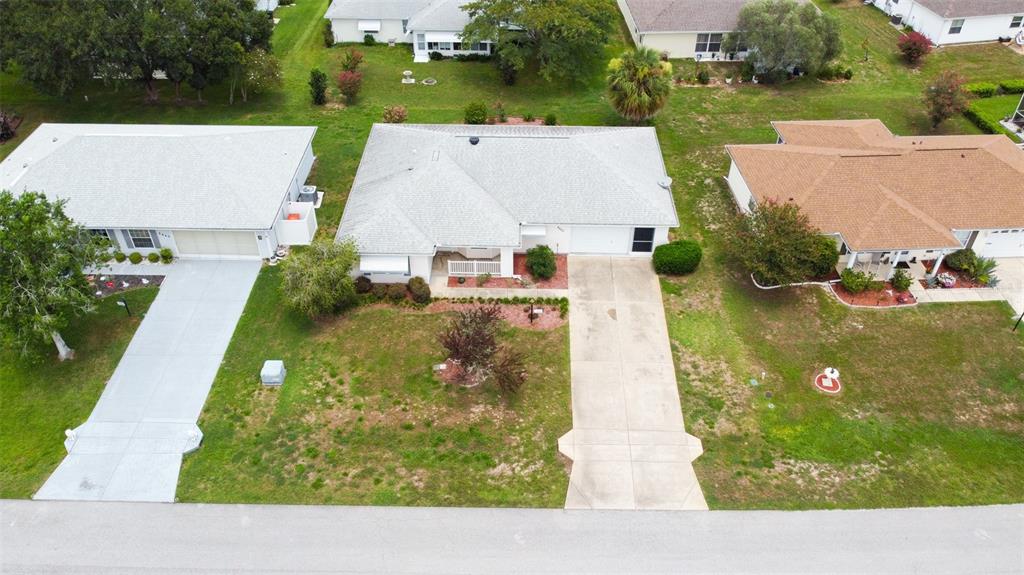 An aerial view shows three suburban houses with driveways and lawns along a paved street — 8480 SW 61ST TERRACE ROAD, OCALA, FL