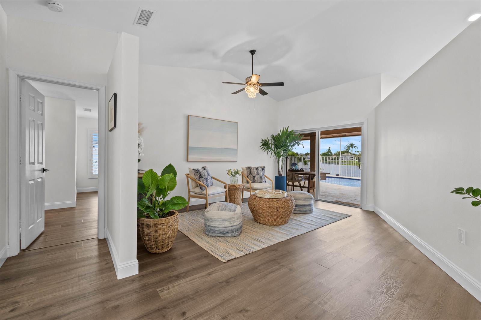 A bright living area features wood floors, a ceiling fan, and sliding doors to a pool — 14211 Appalachian Trail, Davie FL 33325, DAVIE, FL