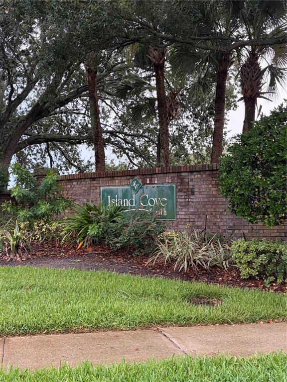 A brick wall displays a sign for Island Cove South behind a landscaped front yard — 14864 LAGUNA BEACH CIRCLE, ORLANDO, FL
