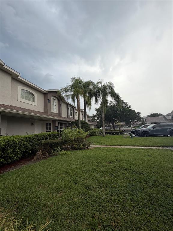 A two-story residential building with a lawn, palm trees, and parked cars — 14864 LAGUNA BEACH CIRCLE, ORLANDO, FL